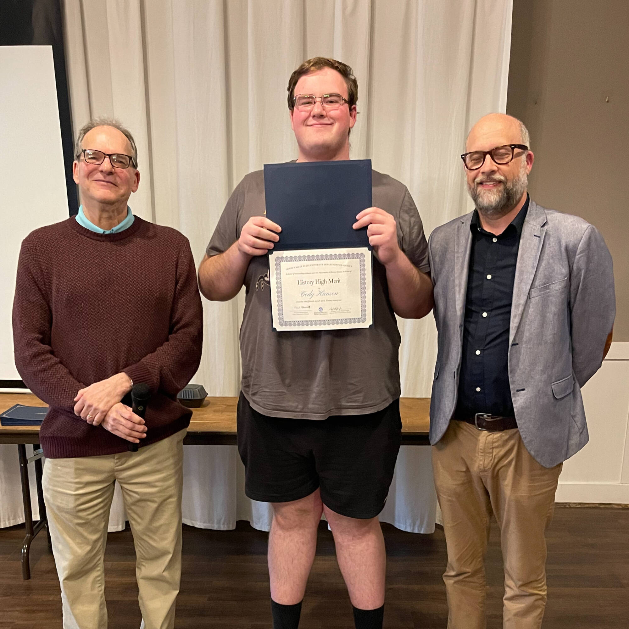 Cody Hansen holding award with professors Montagna & Huner